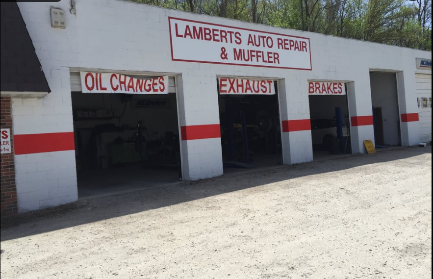 Exterior of Lamberts Auto Repair & Muffler with open service bays labeled Oil Changes, Exhaust, and Brakes.